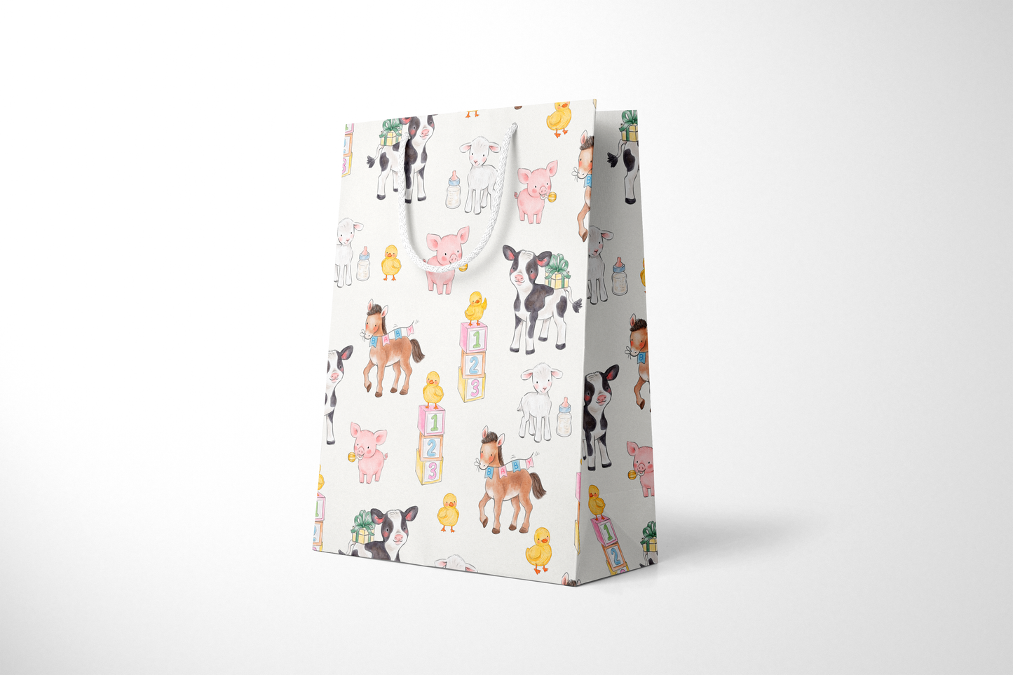 Side view of light cream gift bag featuring a whimsical pattern of baby farm animals, including cows, pigs, lambs, ducklings, and ponies, surrounded by baby bottles, gift boxes, and pastel alphabet blocks, with white rope handles.