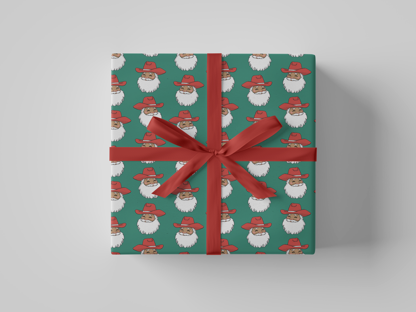 Front view of smiling Cowboy Santa Claus in a red cowboy hat, featured on green-colored Christmas wrapping paper