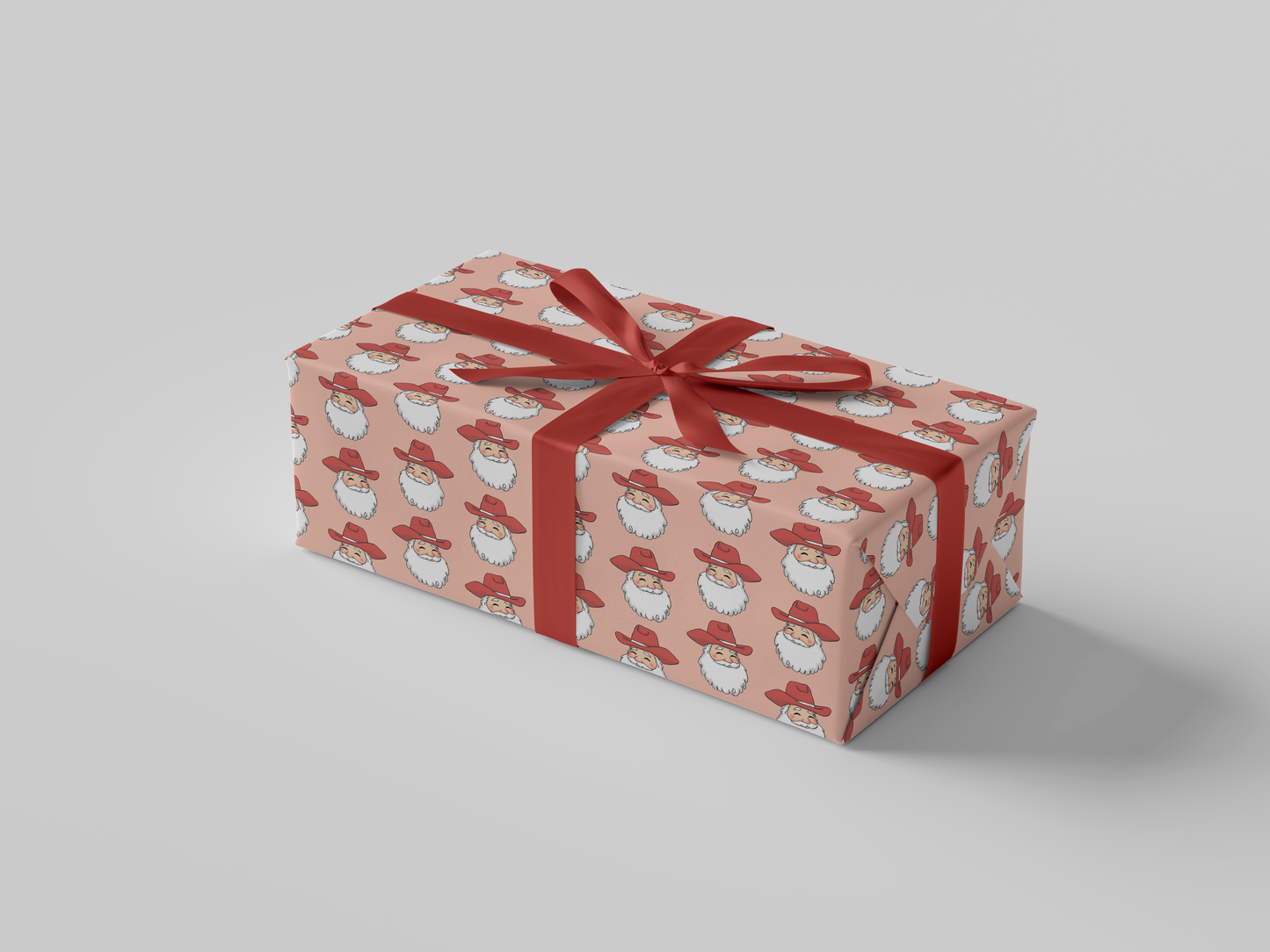 Side view of smiling Cowboy Santa Claus in a red cowboy hat, featured on peach-colored Christmas wrapping paper