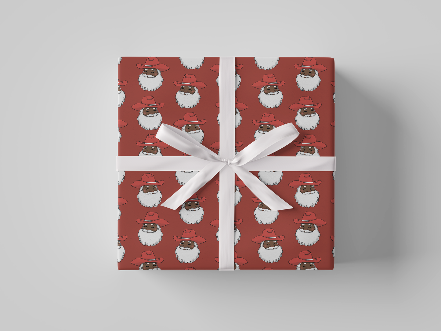 Front view of smiling Cowboy Santa Claus in a red cowboy hat, featured on red-colored Christmas wrapping paper