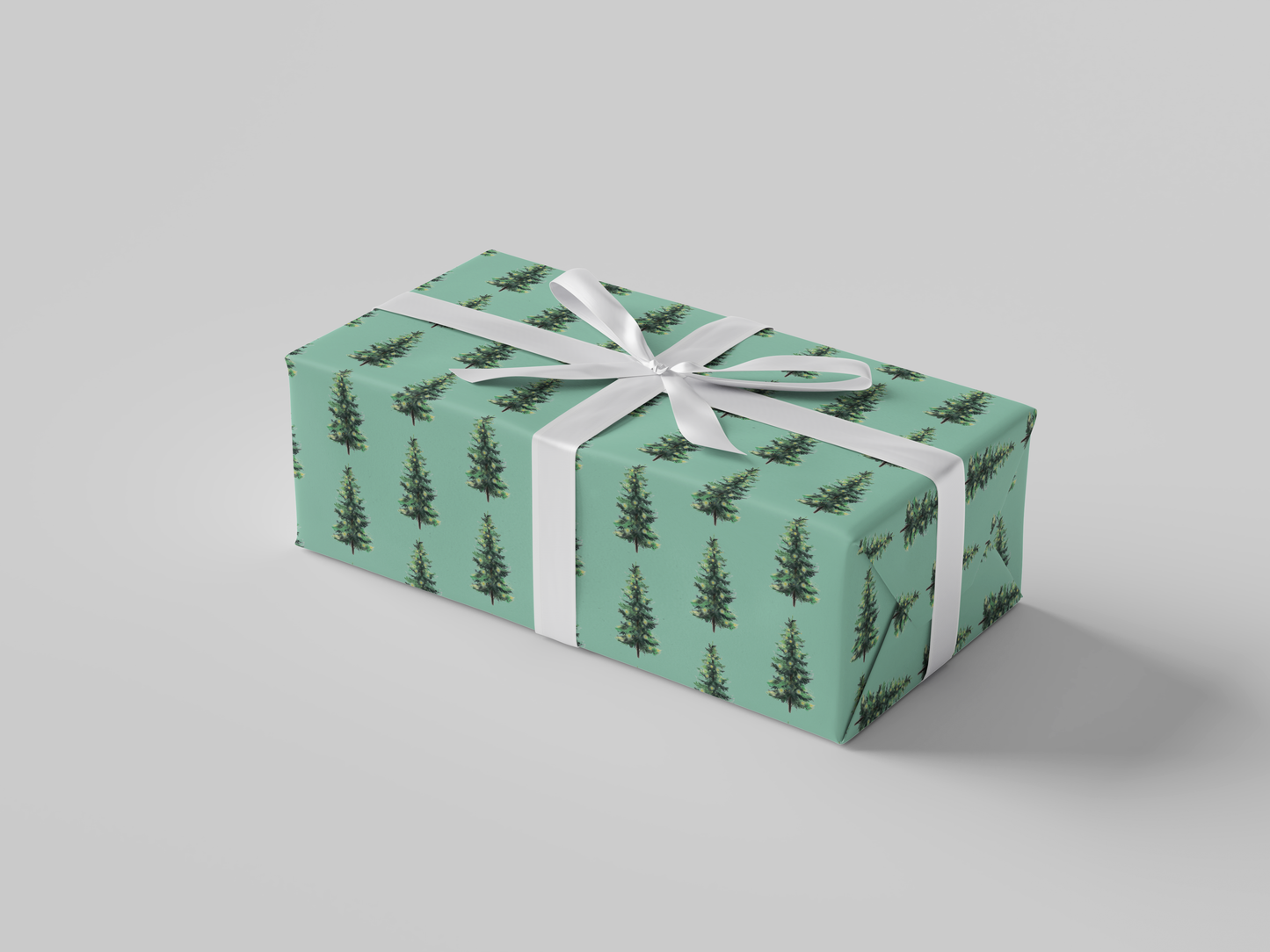 Side view of Christmas wrapping paper featuring dark green Christmas trees with glowing yellow lights on mint green background