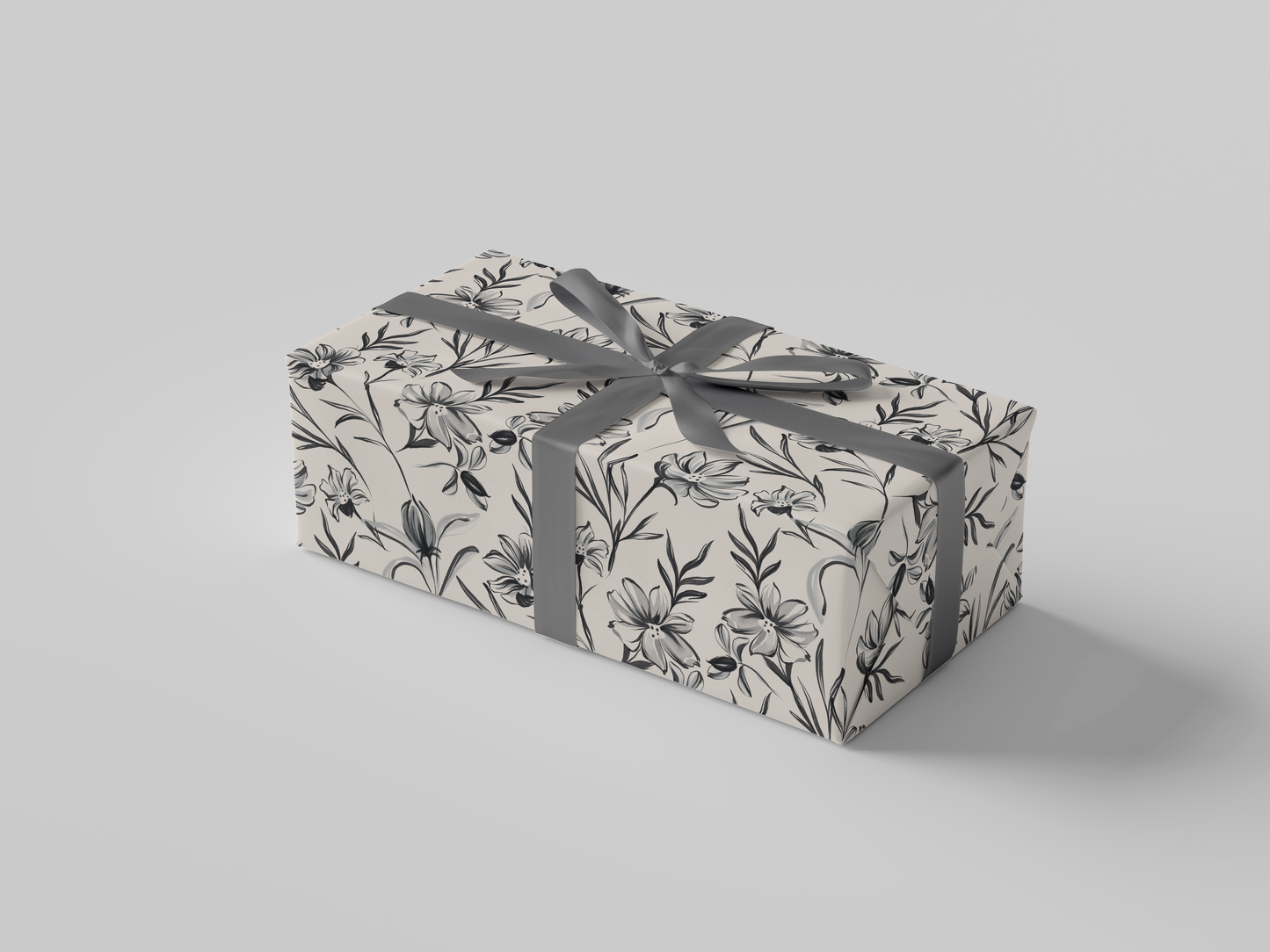 Side view of cream floral-patterned wrapping paper with black , cream and gray flowers and leaves.