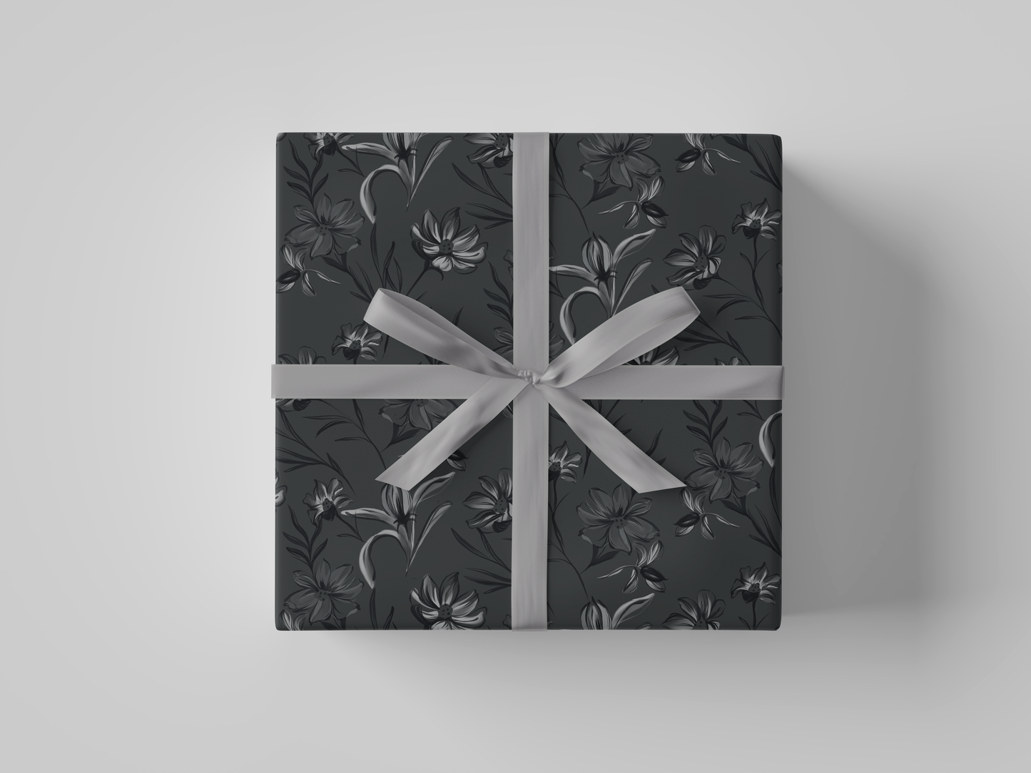 Top view of dark gray floral-patterned wrapping paper with black and gray flowers and leaves.
