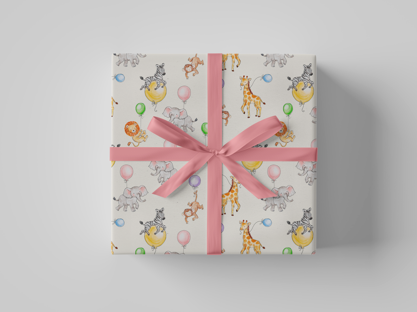 Front view of wrapping paper featuring watercolor illustrations of jungle animals - elephants, giraffes, lions, and zebras - celebrating with colorful balloons on a cream background.