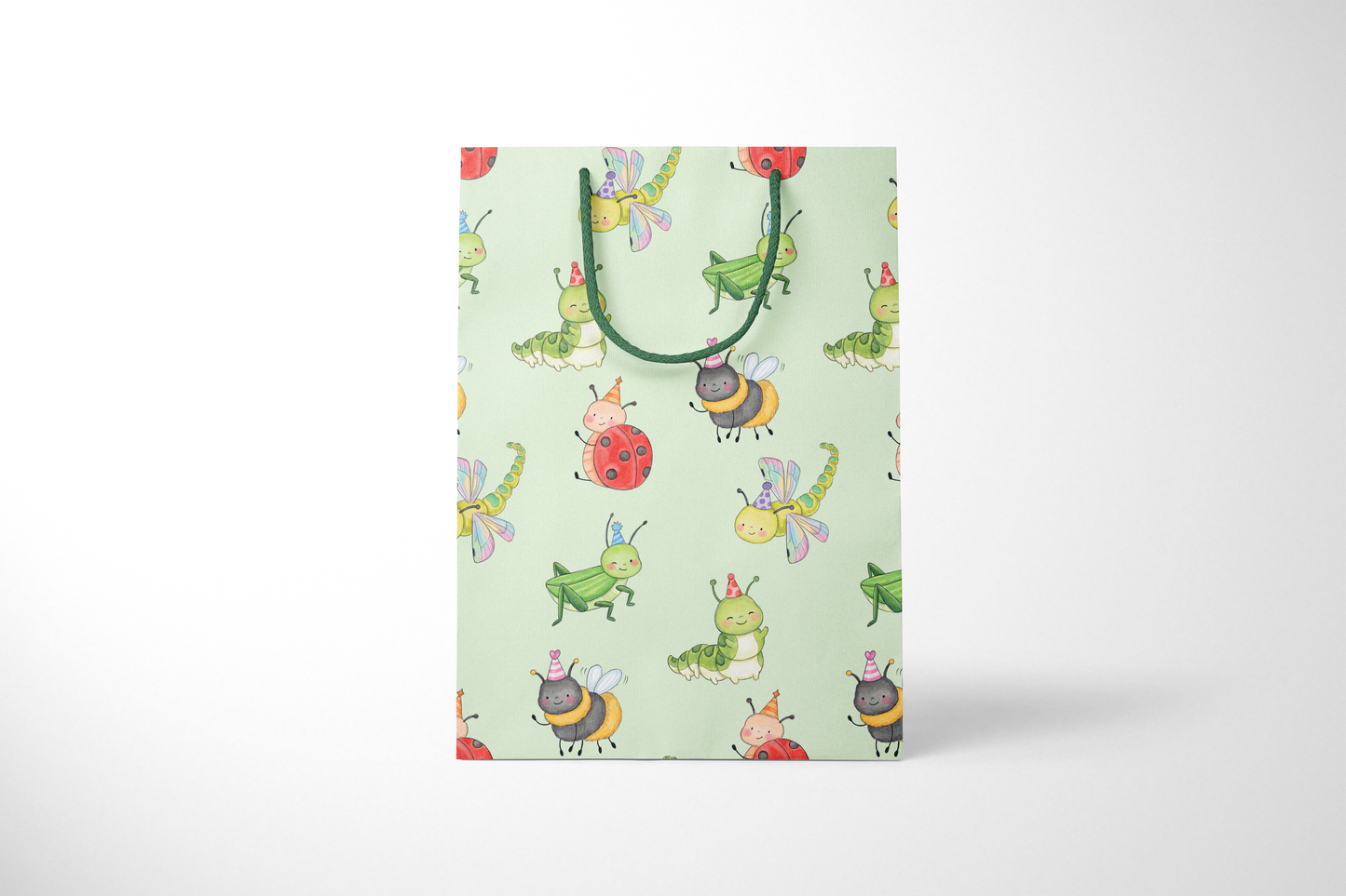 Front view of mint green gift bag featuring a playful pattern of watercolor-style party bugs, including ladybugs, bees, caterpillars, dragonflies, and grasshoppers wearing party hats, with dark green rope handles.