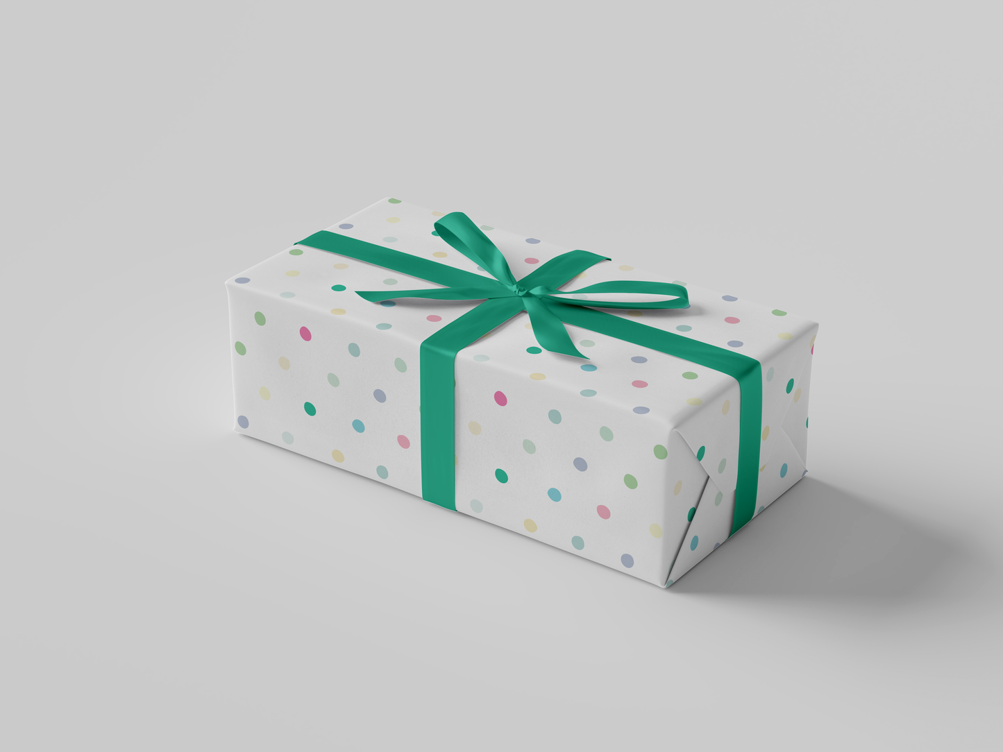 Side view of white wrapping paper adorned with scattered polka dots in soft shades of pink, green, yellow, and blue.