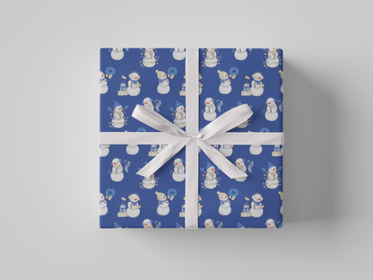 Front view of blue-colored wrapping paper featuring blue and white snowladies holding Christmas gifts, stockings, wreaths, and Christmas tree lights.