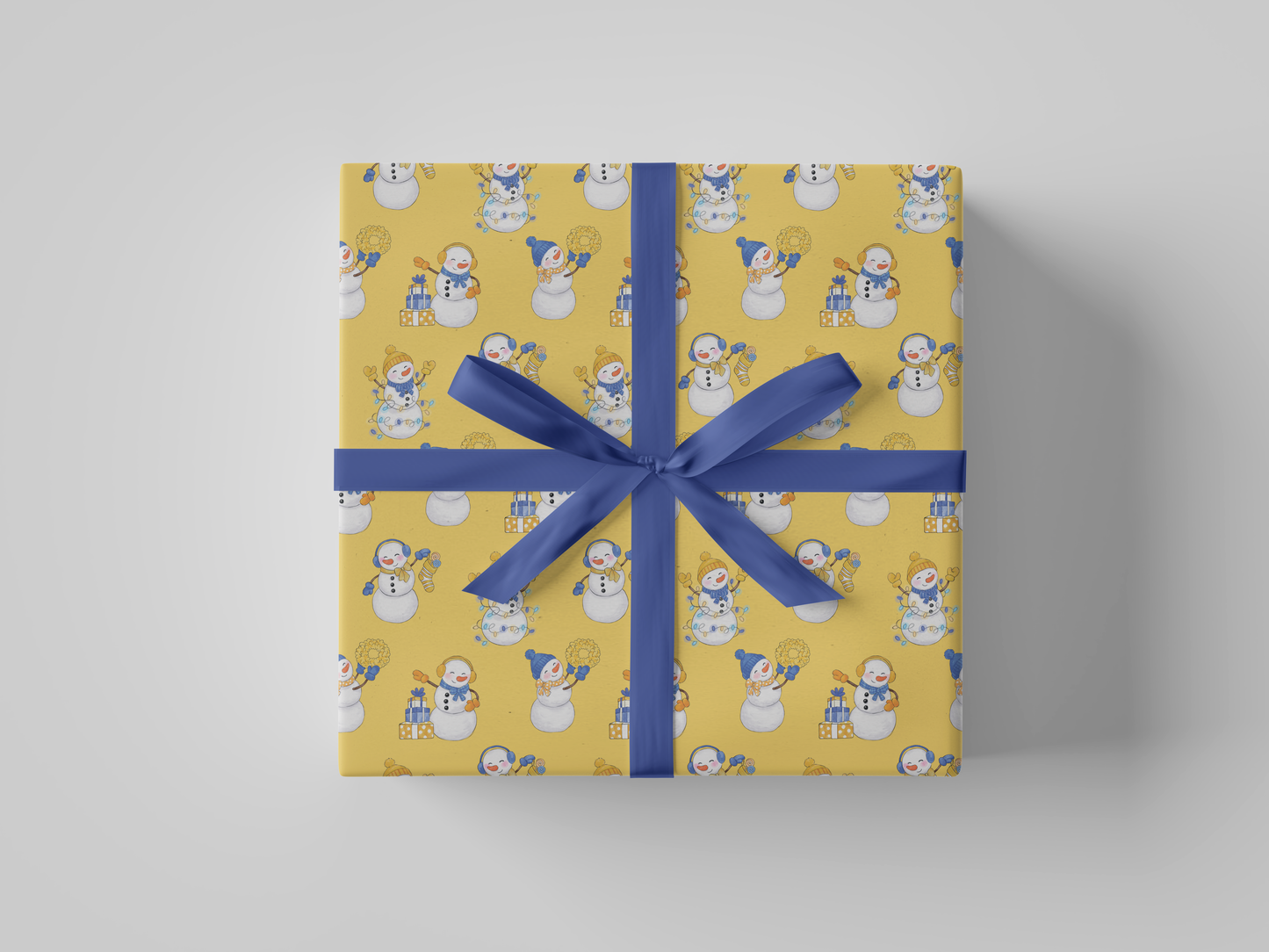 Front view of yellow-colored wrapping paper featuring yellow and blue snowladies holding Christmas gifts, stockings, wreaths, and Christmas tree lights.