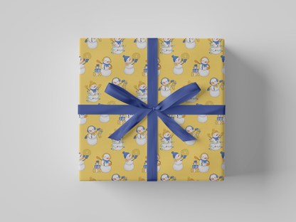 Front view of yellow-colored wrapping paper featuring yellow and blue snowladies holding Christmas gifts, stockings, wreaths, and Christmas tree lights.