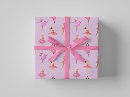 Front view of pink ballerina wrapping paper featuring dancers in pink and purple tutus posed against a soft pink background