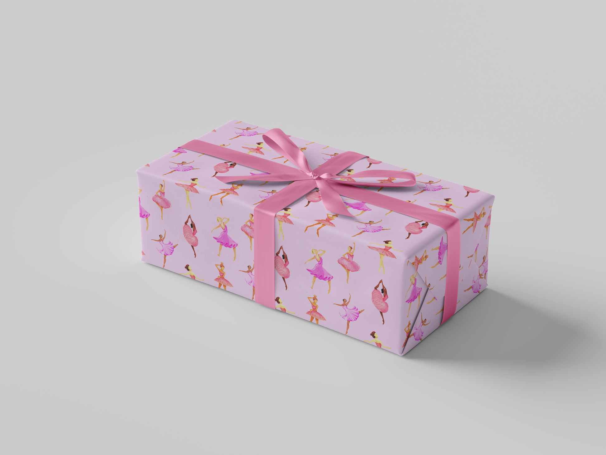 Side view of pink ballerina wrapping paper featuring dancers in pink and purple tutus posed against a soft pink background