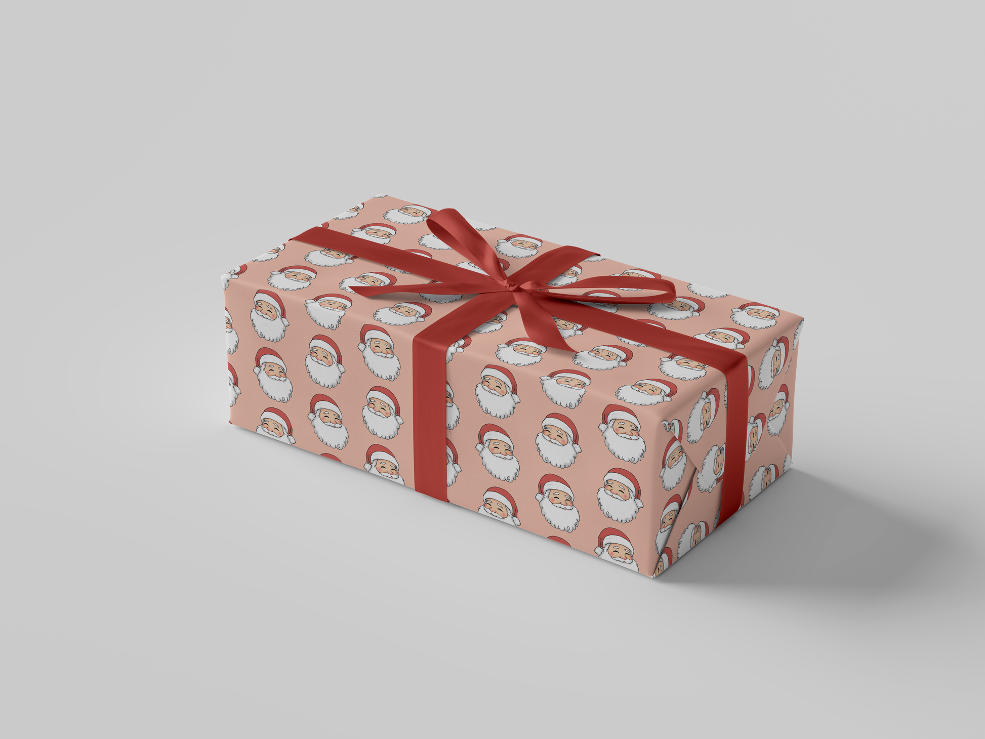 Side view of Christmas wrapping paper featuring a smiling Santa Claus wearing a red hat, set against a peach background.