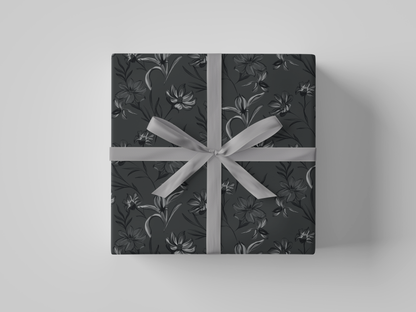 Top view of dark gray floral-patterned wrapping paper with black and gray flowers and leaves.