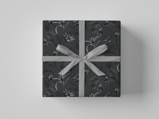 Top view of dark gray floral-patterned wrapping paper with black and gray flowers and leaves.