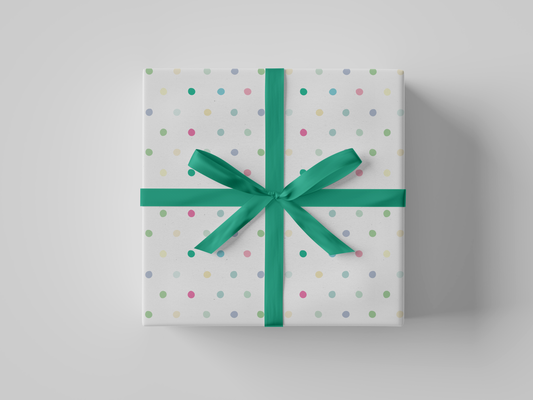 Front view of white wrapping paper adorned with scattered polka dots in soft shades of pink, green, yellow, and blue.